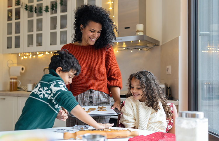 Femme préparant des biscuits avec deux enfants